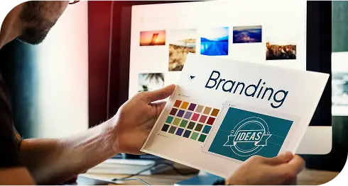 Persona sosteniendo una hoja con una muestra de color y la palabra “branding”, ilustrando la selección de una paleta de colores para la identidad visual de una marca.